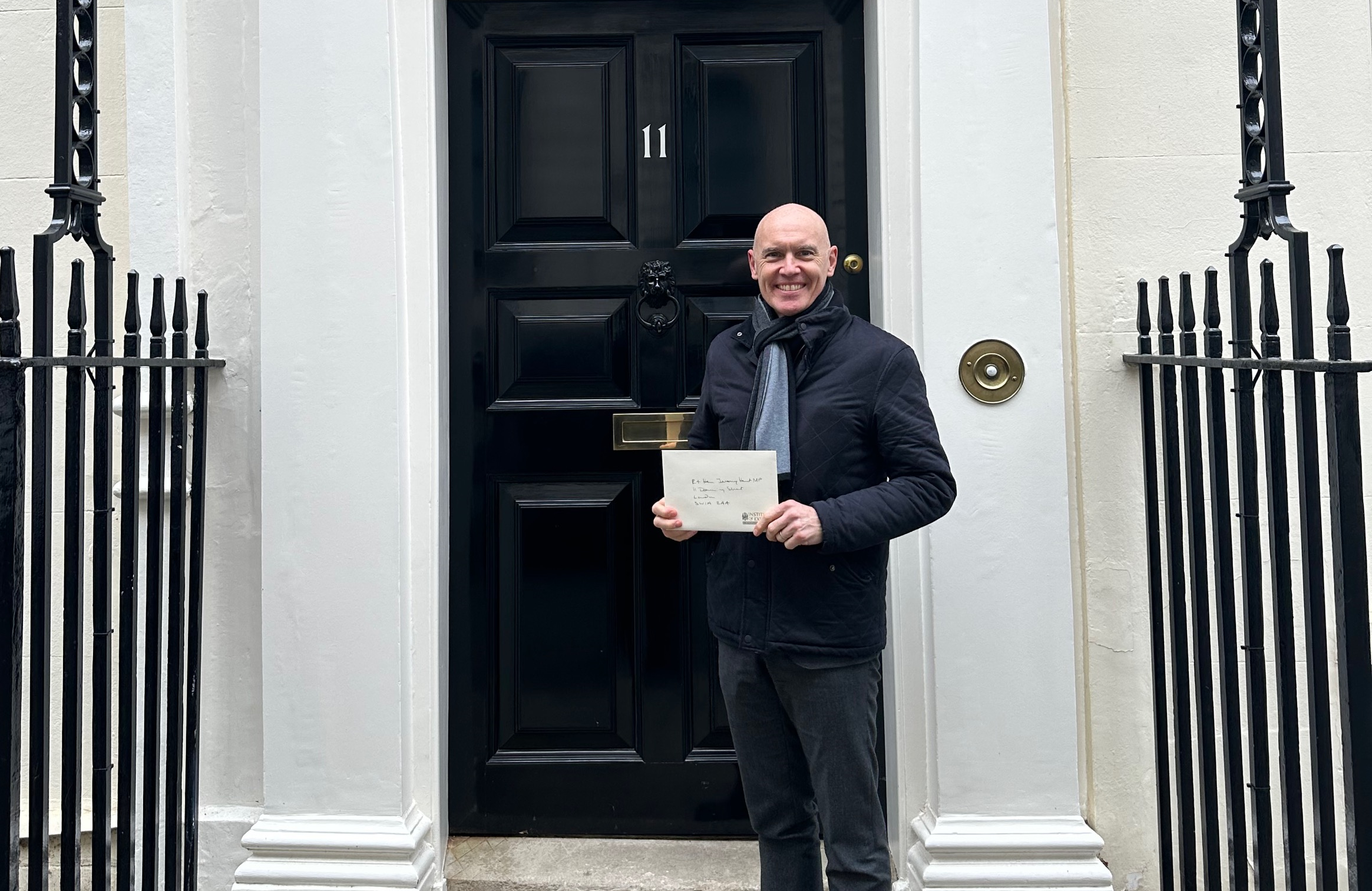 Marco Forgione in front of black door of number 11 Downing Street