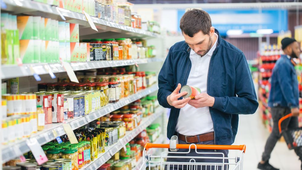 Man looking at food item in supermarket