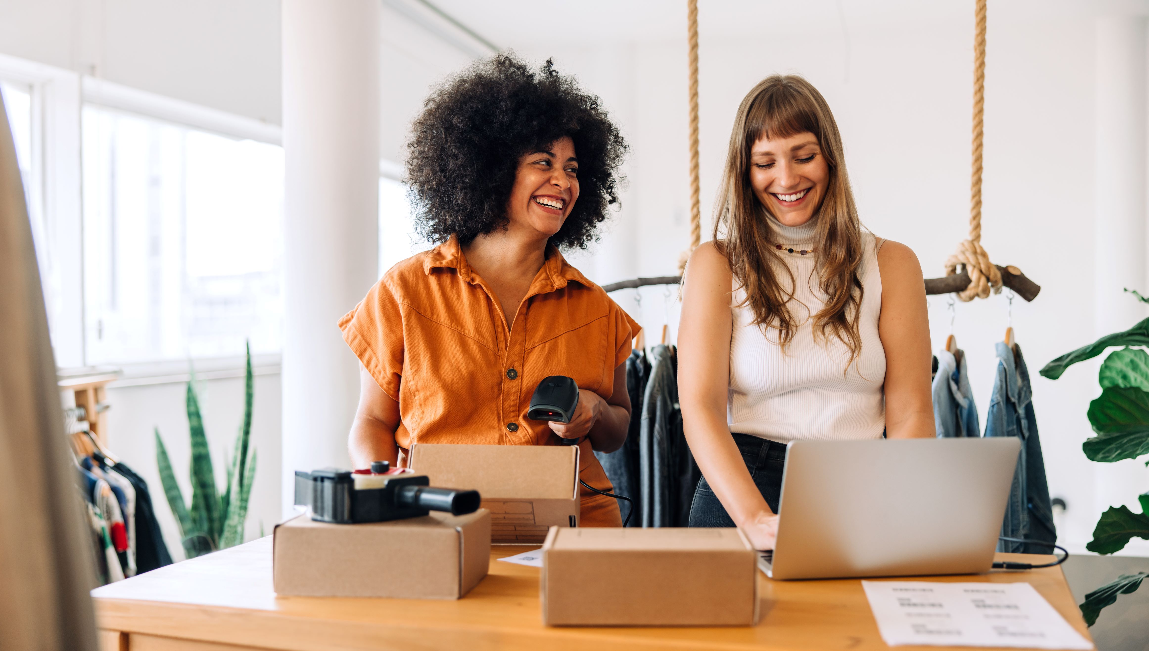 Female businesswomen, one working on laptop