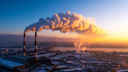 Factory with clouds of smoke emitting from the chimneys during production