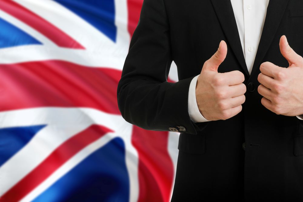 British business - person showing two thumbs up in front of Union Jack