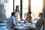Four individuals in a sunny office sat around a conference table