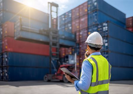 Worker In Front Of Freight Crates