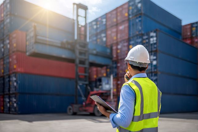 Worker In Front Of Freight Crates